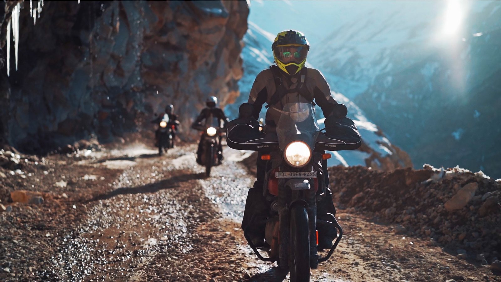 Motorcyclists ride an icy cliff road in the Himalayas, from the QUROST portfolio