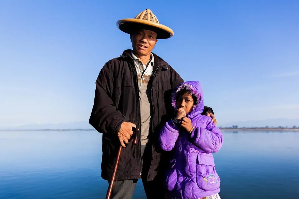 A father and child beside the water in Assam